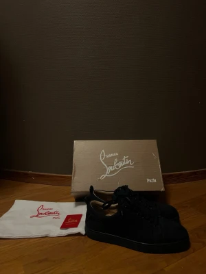 Mörkblåa  sneakers från Christian Louboutin - Mörkblåa sneakers från christian Louboutin i bra skick använda endast några få gånger.