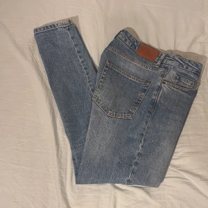 Blå jeans från John Henric - Säljer ett par klassiska blå jeans från John Henric. De har en slim passform. Jeansen är i ett mellanblått tvättat denimtyg och har bälteshällor samt knapp- och dragkedjegylf. Hör av dig vid bud eller frågor!