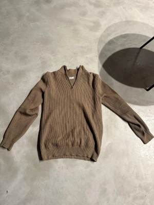 Beige ribbad half zip från John Henric - Säljer en beige ribbad tröja från John Henric i storlek S. Tröjan har en snygg half zip-dragkedja vid halsen och är långärmad med en klassisk passform. Perfekt för lager på lager under höst och vinter.