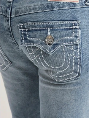 True Religion ljusblå bootcut jeans - Säljer ett par jätte fina ljusblå jeans från True Religion. Jeansen har snygga kontrastsömmar, detaljerade bakfickor med lock och silverfärgade knappar. Klassisk låg midja och stretchigt denimtyg för skön passform. Knappt använda (cirka en gång, inget som syns över huvudtaget) och säljs då dem är lite för stora för mig. För mer bilder och information kontakta mig via plick.❣️