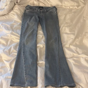 True Religion Joey Low Rise Flare Jeans - Säljer ett par ljusblå jeans från True Religion, modell Joey Low Rise Flare. De har låg midja, utsvängda ben och jag säljer dom för dom Komer inte till användning 
