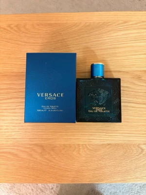 Versace Eros Eau de Toilette - Versace Eros Eau de Toilette 100 ml. En perfym med en doft i snygg blå flaska, perfekt för dig som vill sticka ut och addera en ny känsla till din stil. Volym: 100 ml.