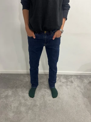 Lee Jeans - Säljer ett par Lee jeans i mörkblå tvätt. Klassisk femficksmodell med normal passform och raka ben. Jeansen har en snygg midja och är tillverkade i slitstarkt bomullsjeansmaterial. Perfekta till vardagslooken. W29 L32