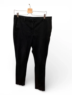 Svarta Chinos från Gant - Snygga svarta Chinos från Gant med raka ben och klassisk passform. Byxorna har bälteshällor, diskreta bakfickor och stängs med dragkedja och knapp. Tillverkade i ett mjukt bomullsmaterial som känns bekvämt hela dagen.