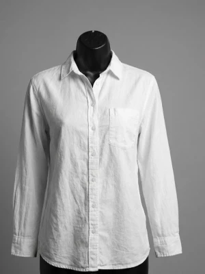 Vit bomullsskjorta med knappar - Vit skjorta i 100% bomull med klassisk krage och knappstängning framtill. Har en bröstficka och långa ärmar med manschett. Perfekt för en clean och chill stil, lätt att matcha med jeans eller kjol.