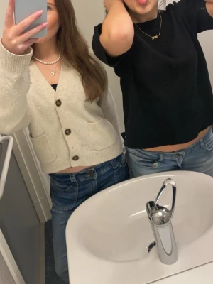 Beige kofta med stora knappar från uniqlo!  - Supermysig beige kofta med stora bruna knappar och två fickor framtill. Koftan har en lite croppad passform och är stickad i ett mjukt material. Tröjan har lite små fläckar som jag inte får bort men tror de går bort om man kör ordentligt. 