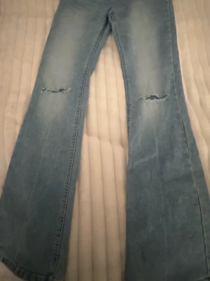 Ljusblå Bootcut jeans med slitningar  - Ljus blå Freja bootcut jeans från Lindex. Bra skick. Använda få gånger. Storlek 170