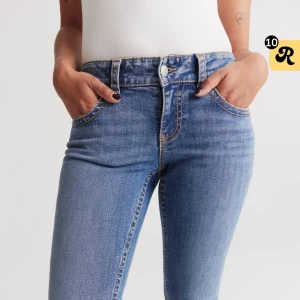 Lågmidjade jeans - Modell y2k low waist bootcut jeans i blå färg med knappar på fickorna. Lite slitna längst ner på ena benet där av priset, annars i fint skick. Nypris 500kr. Skriv privat för fler bilder eller funderingar 