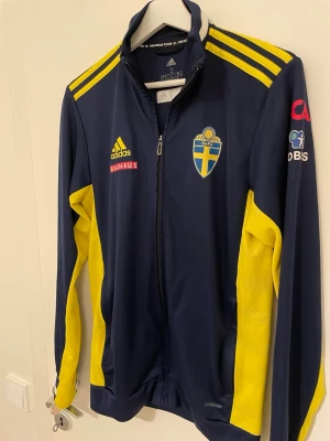 Svensk landslagsträningströja Adidas - Mörkblå och gul träningströja från Adidas med Sveriges landslagsemblem på bröstet. 