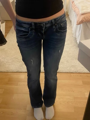Blå bootcut jeans från LTB 27/30 - Säljer ett par lågmidjade blå bootcut jeans från LTB med slitningar och snygg tvätt. Modell Valerie och färg Cordelia Wash i storlek 27/30. Haft i cirka ett år men sparsamt använda då de är lite stora för mig. 