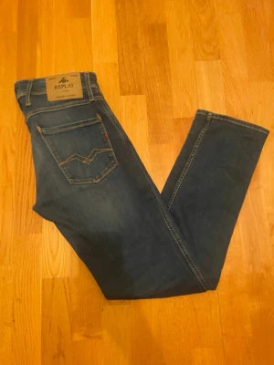 Blå Replay jeans med raka ben - Säljer nu mina riktigt snygga blå Replay Anbass slim fit jeans| och diskreta slitningar. Jeansen har en slim passform och sitter riktigt fint med sitt stretchiga material denim för extra komfort| storlek W30 L32|jag är 183cm och dom sitter lite för tight och lite korta på mig| Perfekta för dig som gillar en stilren look med lite edge| Skriv vid fundering💭