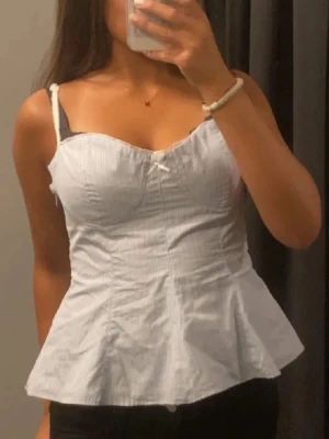 Ljusblå peplum korsettopp med rosett - Söt topp från Zara med spets axelband(justerbara). Liknande en korsett fast inte så tajt som vanligtvis. Storlek M och använt 3 ggr💕