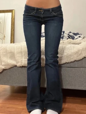 Mörkblå bootcut jeans lågmidjade - Säljer ett par mörkblå lee jeans med bootcut-modell och låg midja. Midjemått: 38cm. Innerbenslängd: 80cm  skriv vid frågor💞💞