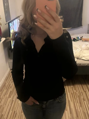Svart långärmad topp med knappar - Säljer en svart långärmad topp med knappar framtill. Toppen har en snygg passform och är enkel att matcha med olika outfits. Perfekt basplagg för garderoben och passar till både jeans och kjol. Ifrån Gina Tricot. Nypris-vet ej Säljer för-25kr. Säljs billigt då ja vill bli av med den❣️