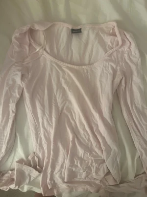 Ljusrosa långärmad topp Monki - Säljer en ljusrosa långärmad topp från Gina Toppen har en rundad, något djupare halsringning och är tillverkad i mjuk bomull. Perfekt att styla med jeans eller kjol för en enkel och fräsch look.