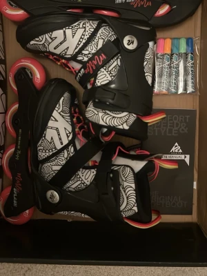 K2 inlines med grafiskt mönster - Säljer ett par K2 inlines med svart och vitt grafiskt mönster, svarta detaljer och rosa hjul. Skorna har spännen och snörning för bra passform. Perfekt för dig som vill rulla snyggt i stan eller parken. Manual och färgpennor medföljer. Färgpennorna är gjorda för att rita på skorna i storlek 32-37 