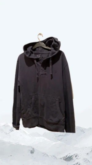 Mörkblå hoodie från Polo Ralph Lauren - Snygg mörkblå hoodie från Polo Ralph Lauren med huva och snörning. Tröjan har en klassisk känguruficka framtill, knappar vid halsen och långa ärmar. Tillverkad i mjuk bomull som är skön att ha på sig. Perfekt för chill dagar eller när du vill ha en avslappnad stil.