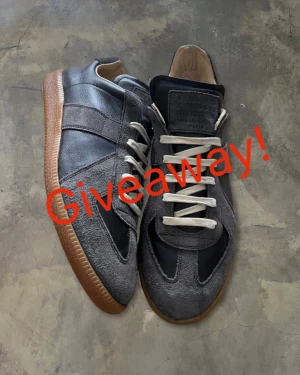 Grå Maison Margiela sneakers - 🚨För att delta FÖLJ MIG OCH GILLA ANNONSEN🚨. Maison Margiela sneakers i grå mocka och skinn med svarta paneler och beige gummisula. Skorna har rund tå, snörning och kontrasterande vita skosnören. Perfekt för dig som gillar stilrena och unika sneakers med lyxig känsla. 