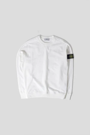 Vit Stone Island sweatshirt - Vit sweatshirt från Stone Island med klassisk rund hals och ribbade muddar. Tröjan har den ikoniska svarta patchen med gul logga på vänster ärm. Tillverkad i mjuk bomull för en clean och stilren look.