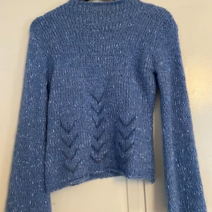 Blå stickad tröja från Jinda - Superfin blå stickad tröja från Jinda i storleken xs-S med lång ärm och snygga stickade detaljer framtill. Varm och mysig känsla, passar perfekt till kallare väder.