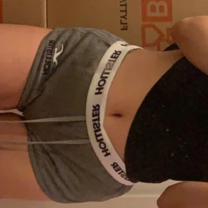 Grå shorts från Hollister med snörning - Snygga grå shorts från Hollister med bred resår i midjan och tydlig logga. Mjukt material och snörning framtill för extra komfort. Perfekta för chill eller träning, med en loose passform och sportig vibe. Knappt använda 