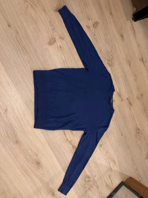 Marinblå tröja från Dressmann M - Snygg marinblå tröja från Dressmann i mjuk pima bomull. Klassisk rund hals och långärmad modell med ribbade muddar vid ärmslut och nederkant. Perfekt för dig som gillar stilrena och enkla plagg med skön passform. 100% Bomull