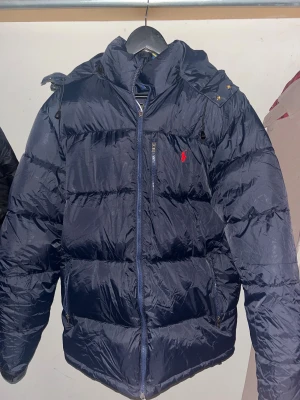 Polo Ralph jacka - Säljer en helt ny mörkblå pufferjacka från Polo Ralph Lauren, väldigt fin och helt oanvänd samt etiketten på, säljer den eftersom den va lite för stor. Priset kan så klart diskuteras, så hör av er!