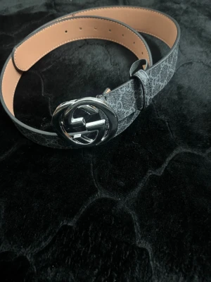 G bälte  - Snyggt G bälte för ett bra pris. Bältet är gjort i skinn med tryckt canvas och har en stilren, modern vibe som lyfter vilken outfit som helst.