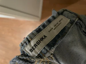 Blå denimshorts med snörning från Bershka - Säljer en byxdress i denim från Bershka i storlek XS. Jeansen har en loose passform och toppen är tight. Tillverkade i bomull med klassisk jeanslook och ljus tvätt. 