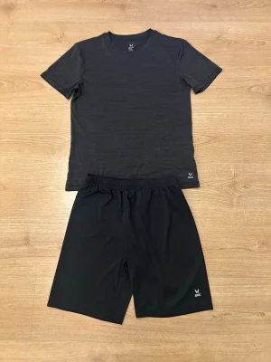Träningskit - Säljer ett svart träningsset från SOC med t-shirt och shorts. Båda plaggen är tillverkade i ett lätt och snabbtorkande funktionsmaterial som andas, perfekt för träning eller sport. Diskret SOC-logga på både tröja och shorts.