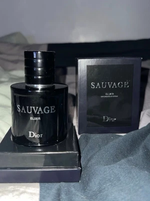 Dior Sauvage Elixir parfym - Dior Sauvage Elixir är en exklusiv herrparfym i en elegant, mörkblå glasflaska med silverfärgad text. Flaskan har en rund, robust form och kommer med originalkartong. En lyxig doft som sticker ut och känns modern.