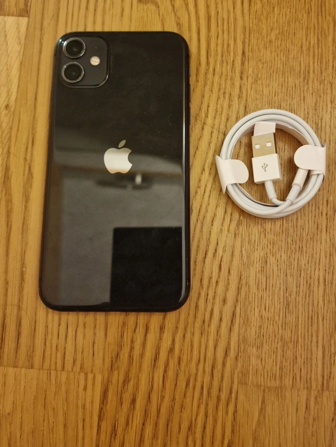 Svart iPhone 11 med laddkabel