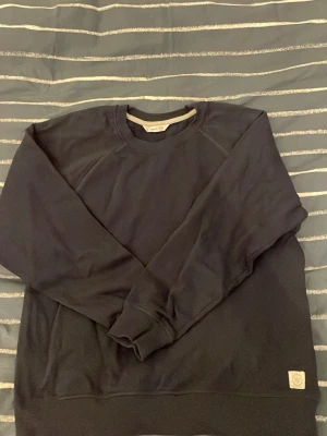 Mörkblå sweatshirt från mango - En stilren mörkblå sweatshirt från mango med rund halsringning och ribbade muddar vid ärmslut och nederkant. Tröjan har en klassisk passform och är tillverkad i mjukt material, perfekt för en avslappnad look. Storleken är M men sitter som S/XS. Pris kan gå ner vid snabb affär!