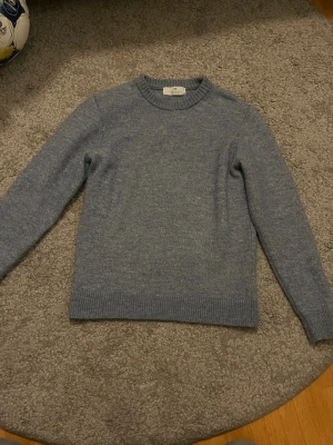 Ljusblå stickad tröja från Soft Goat - Mysig ljusblå stickad tröja från Soft Goat i klassisk modell. Tröjan har rund halsringning, ribbade muddar och är långärmad. Perfekt för lager-på-lager och enkel att matcha med olika outfits.