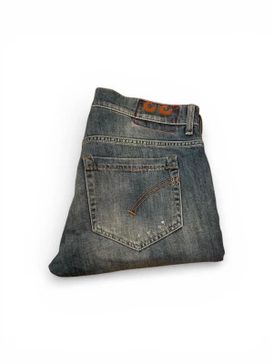 Dondup Jeans - Snygga blå Replay jeans med slitna detaljer och klassisk femficksdesign. Jeansen har raka ben och en cool tvättad look med slitningar på låren och knäna. Perfekta för dig som gillar en avslappnad och trendig stil.