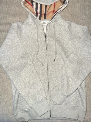 Grå BURBERRY zip hoodie - Hej! Säljer denna tvär feta BURBERRY zip hoodien då den är för liten! Den är helt oanvänd har bara prövats en gång! Storleken är S men den sitter som XS, skulle säga 170!! Hör gärna av er vid intresse, snabb leverans!! Mvh//Mio