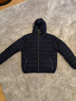 Ralph Lauren dunjacka - Säljer nu min dunjacka från Ralph Lauren då den var aningen liten för mig själv. Snygg passform som man kan vända ut och in för att jackan antingen blir blå eller grön perfekt för att matcha outfits. Bara och ställa mer frågor i dm om ni undrar något!