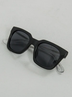 A.kjærbede solglasögon - Juvligt schyssta solglasögon med svart rektangulär front och transparenta skalmar. Snygg kontrast mellan bågens färger och mörka glas. Perfekt accessoar för en mango fet look. 