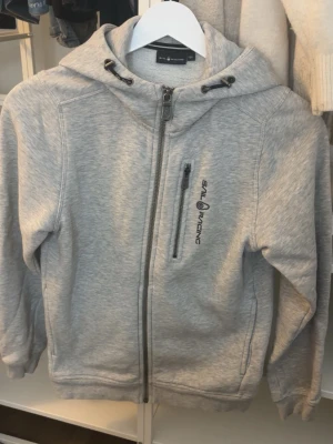 Sail racing zip up - grå zip up från sail racing, säljer då den knappt kommer till användning. Storlek 150 men är större i storlek så går och använda när man är 160.