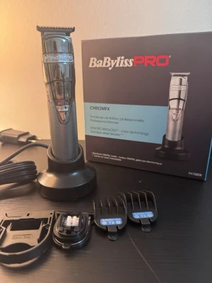 BaBylissPRO CHROMFX trimmer - BaBylissPRO CHROMFX professionell trimmer i silver med laddningsstation, tre kammar, extra tillbehör och originalkartong. Trimmern har ett stilrent metallhölje och är sladdlös med uppladdningsbart batteri. Perfekt för detaljerad trimning och styling.  KÖPT FRÅN ELGIGANTEN 