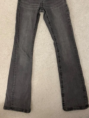 grå low waist bootcut jeans från gina - säljer ett par superfina grå low waist bootcut jeans från gina! de är i strl 32, de är använda ett fåtal gånger❣️