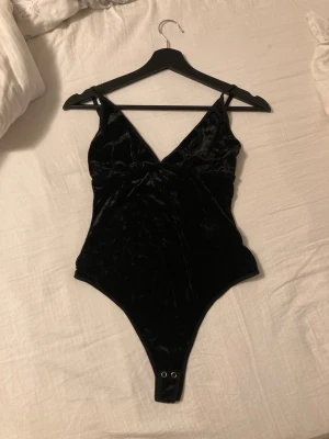 body i sammet - sjukt fin svart high cropped body i mjukt sammet. köpt second hand i köpenhamn men ej använd av mig. inga defekter. perfekt till såväl utekvällar som till vardags. passar xs/s.