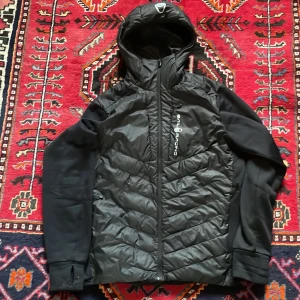 Sail racing jacka - En snygg Sail Racing cardigan som passar perfekt till hösten men håller värmen för vintern också. Rivmärket i jackan är täckt av luvan på nacken,Priset är ej hugget i sten