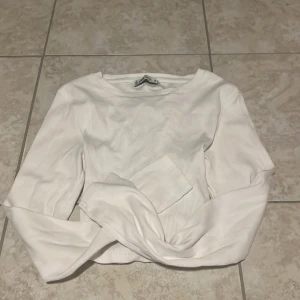 Vit ribbad långärmad topp med knytning bak - Säljer en vit ribbad långärmad topp från FB Sister från New Yorker i storlek S. Toppen har snygg snörning baktill. 