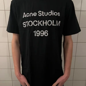 Acne studios t shirt  - Riktigt fet och eftertraktad t shirt med acne studios loggan. Storlek M, skick 10/10!! Modellen på bilden är 183cm. Är lite osäker på äktheten eftersom lappen i nacken saknas så därför är priset just nu på 599kr! Nypris runt 4000! Tveka inte med att ställa frågor!