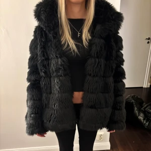 Svart fluffig pälsjacka - Säljer en svart pälsjacka med fluffig och lyxig känsla. Storlek 38 från NLY trend. Materialet är akryl och polyester. Perfekt höstjacka eller vinterjacka.