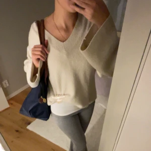 Vit stickad v-ringad tröja - Säljer en vit stickad tröja med v-ringning och breda, långa ärmar. Den är från Gina och nypriset är 400kr🤍