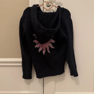 Jettesnygg zip up hoodie med tryck på baksidan - Fin zip up hoddie från natura, köpt i Spanien. Mitt pris är 400kr + frakt som kunden betalar, priset kan diskuteras. Den ser svart ut på bilden men den är mörkblå