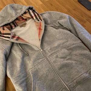 Grå burberry zip-up - Säljer min gråa burberry zip up! Den e storlek L men burberrys storlekar e småa enligt deras egna hemsida, så jag skulle säga att denna motsvarar S eller en liten M! Hör av er vid frågor o pris kan diskuteras!