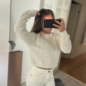 Vit stickad tröja från Gina Tricot - Säljer en vit stickad tröja från Gina Tricot i storlek XS. Tröjan har ribbad struktur, croppad passform och rund hals. Långärmad och mjuk i materialet, perfekt för lager-på-lager under kyliga dagar. Enkel och stilren design som är lätt att matcha.